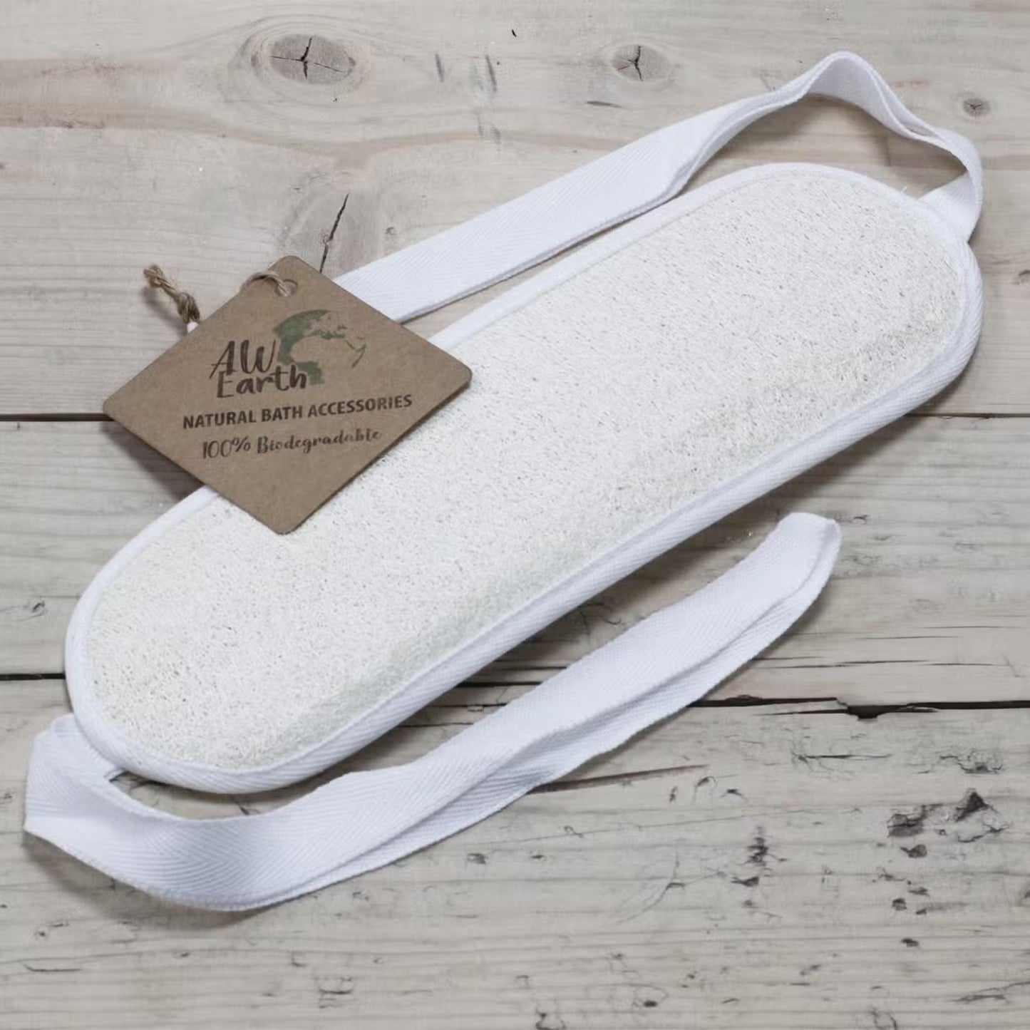 White bath pouf with a brown tag on a wooden surface