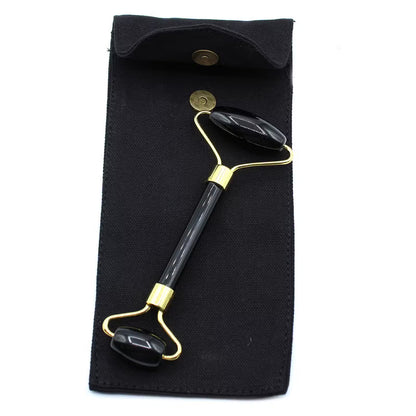 Black and gold facial roller on a black pouch with a white background