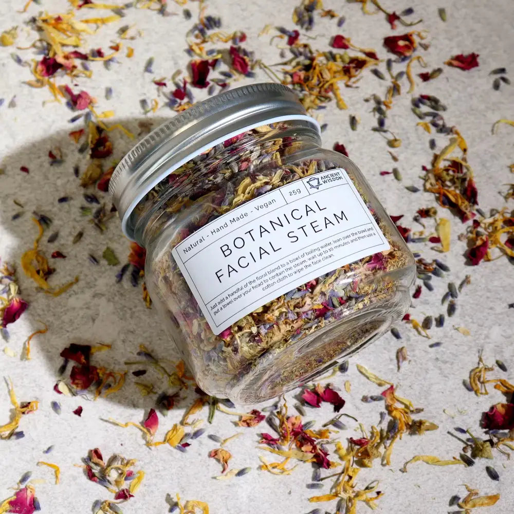 Jar of Botanical Facial Steam with dried flowers on a textured surface