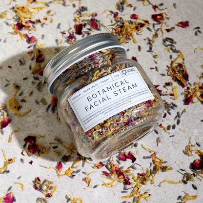Jar of Botanical Facial Steam with dried flowers on a textured surface