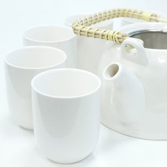 White ceramic teapot and cups on a white background