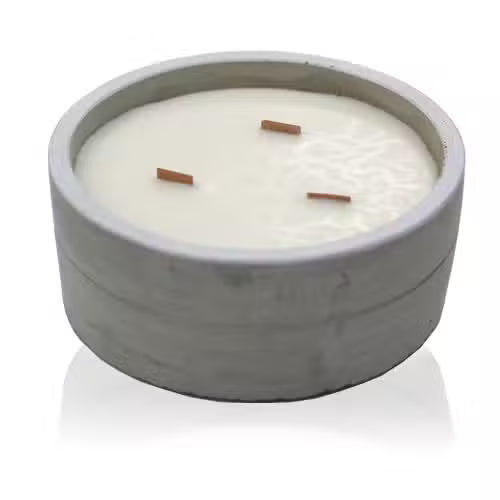 Candle in a concrete holder with three wooden wicks on a white background