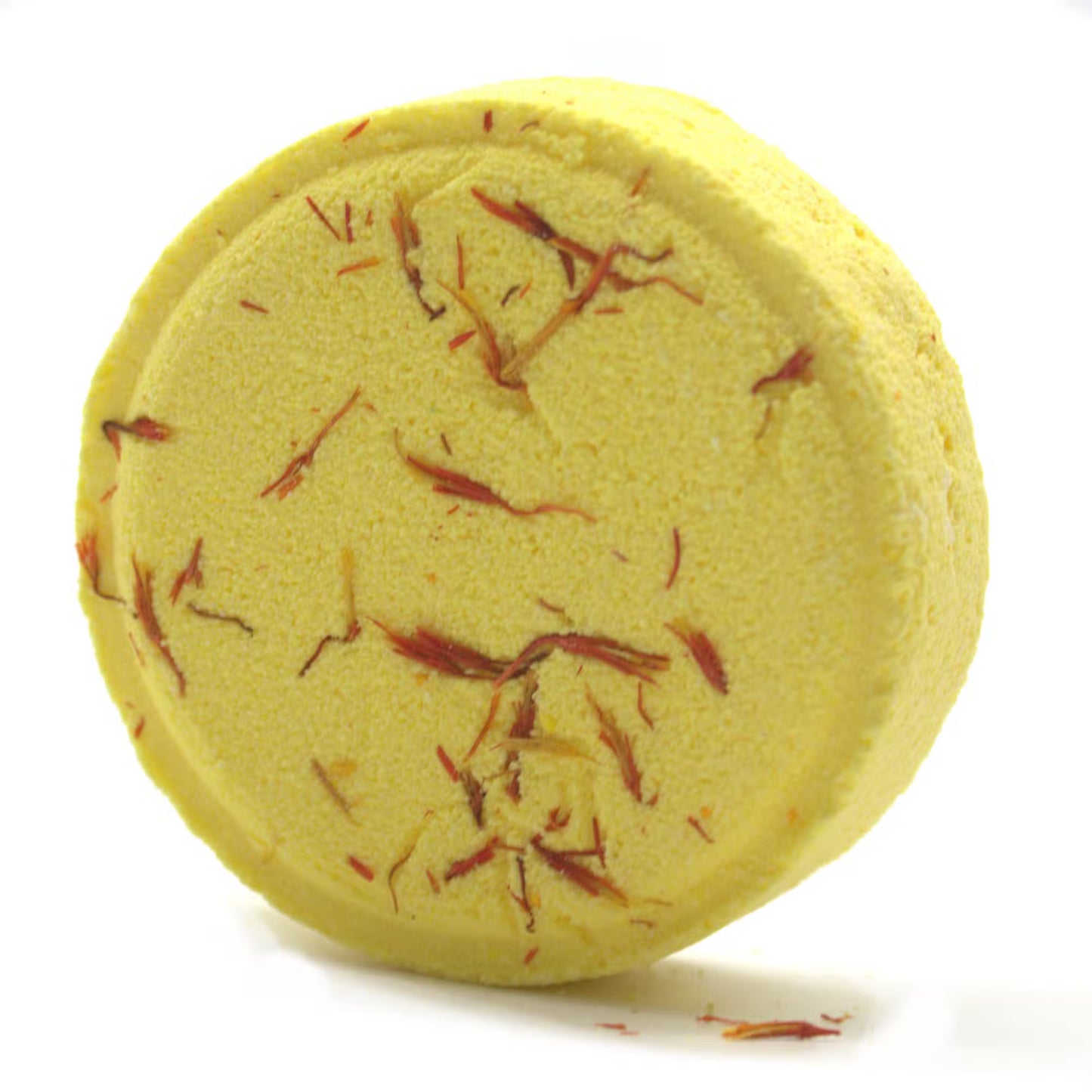 Yellow bath bomb with red specks on a white background