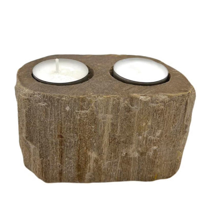 A rustic stone candle holder carved to hold two white tea light candles, shown against a plain white background.