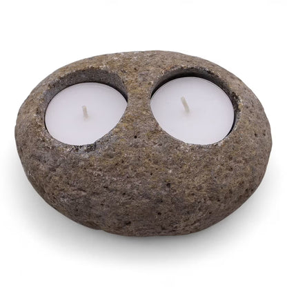 Rustic stone candle holder with two white candles on a white background
