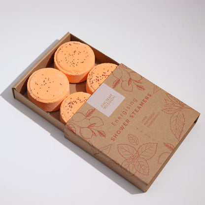 Box of orange shower steamers with a brown cardboard box on a white background