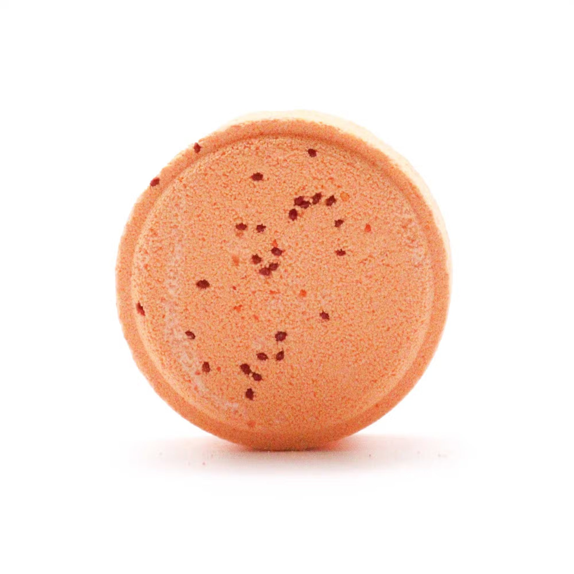 Round orange bath bomb with specks on a white background