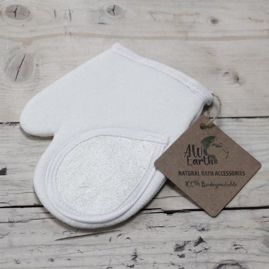 White textured bath mitt with a brown tag on a wooden surface