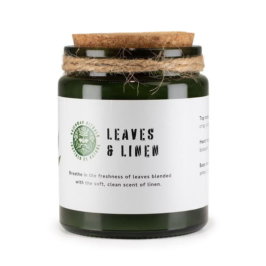 Candle jar labeled 'Leaves & Linen' with a cork lid on a white background