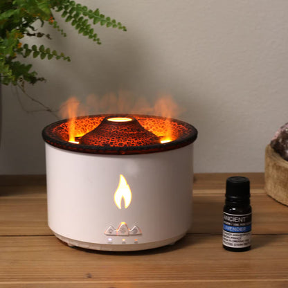 White flame diffuser with decorative interior on a wooden surface next to a bottle of essential oil.