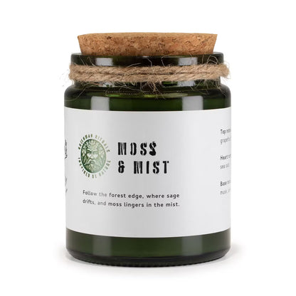 Candle jar labeled 'Moss & Mist' with a cork lid on a white background