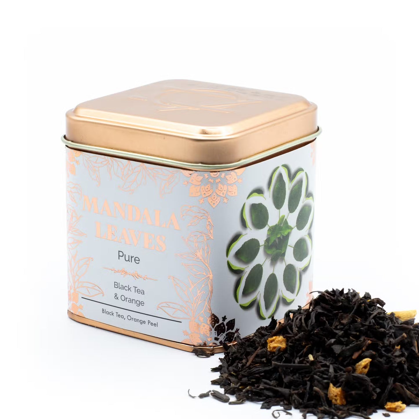 Tea tin with floral design and black tea leaves on a white background