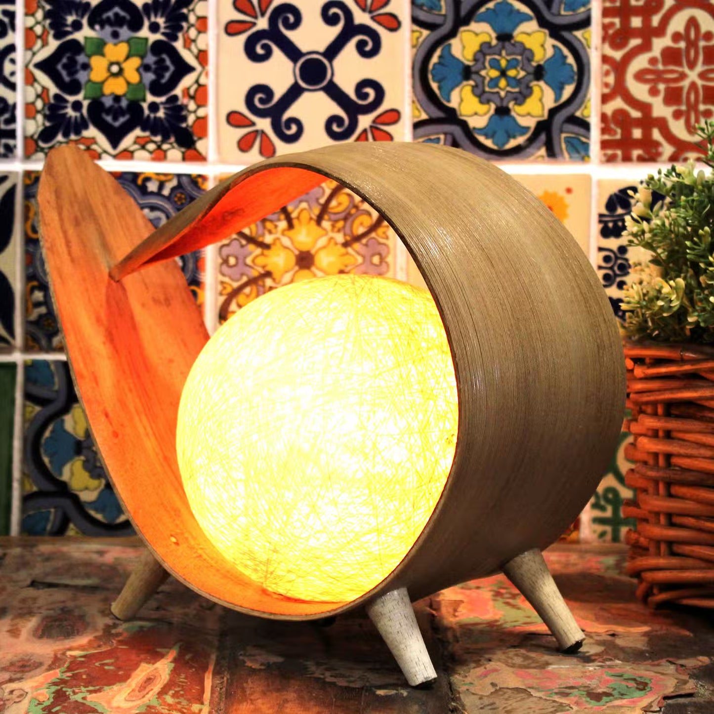 Decorative lamp with a warm glow against a colorful tile wall.