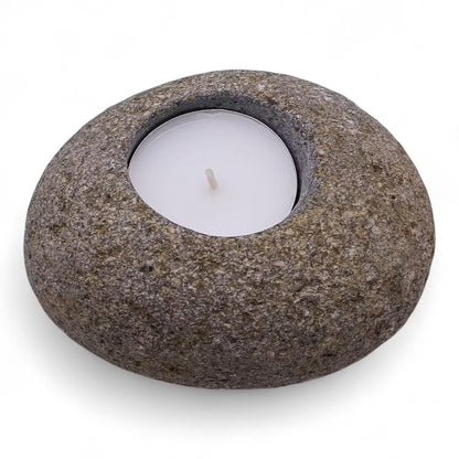 Stoneware candle holder with a white candle on a white background