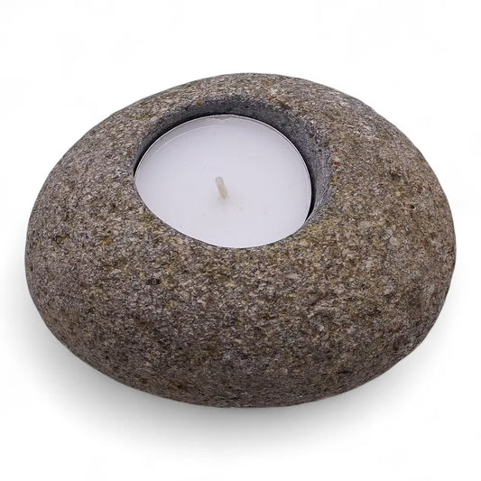 Stoneware candle holder with a white candle on a white background