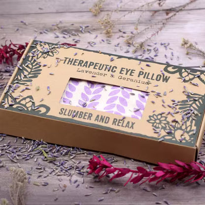 Therapeutic eye pillow packaging with lavender and geranium on a wooden surface.