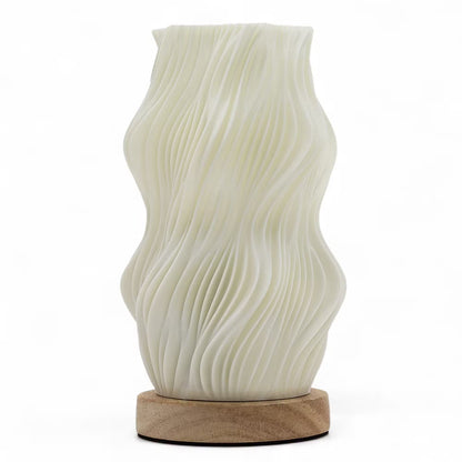 An off-white ceramic vase with a wavy, pleated texture, displayed on a round natural wood base against a clean white background.