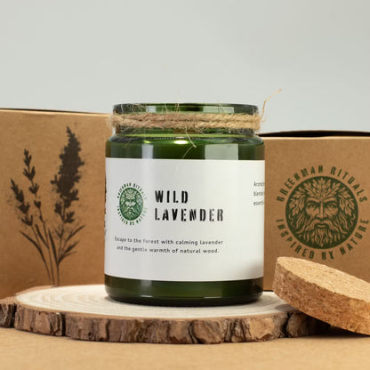 Green candle labeled 'Wild Lavender' on a wooden surface with a branded box in the background.