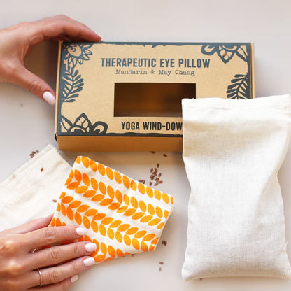 Therapeutic eye pillow with packaging and a small pouch on a light surface