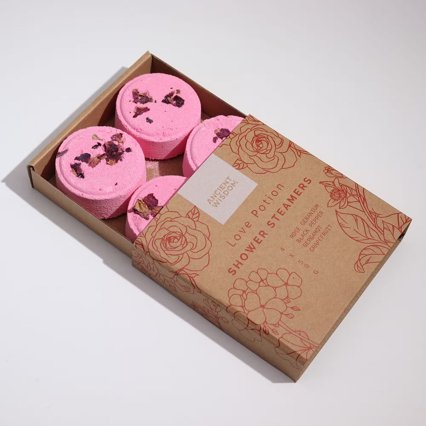 Box of pink shower steamers with decorative packaging on a white background