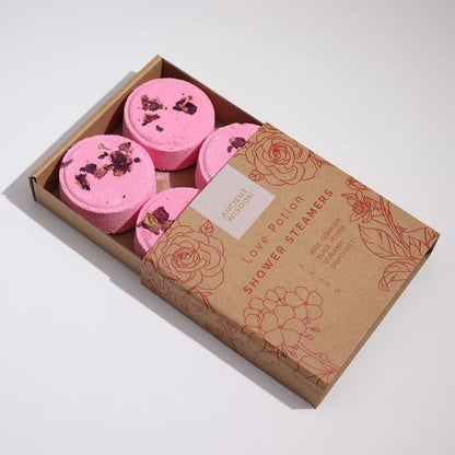 Box of pink shower steamers with decorative packaging on a white background