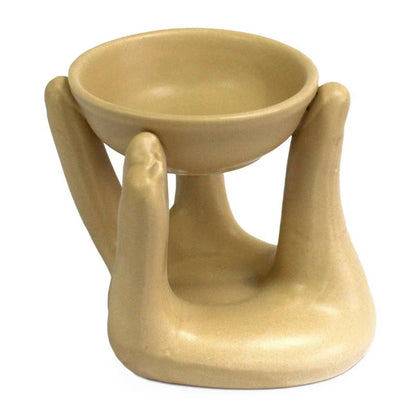Beige ceramic oil burner with two handles on a white background