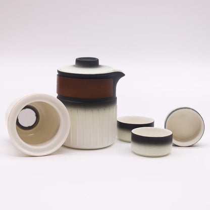 Ceramic tea set with a teapot and four cups on a white background