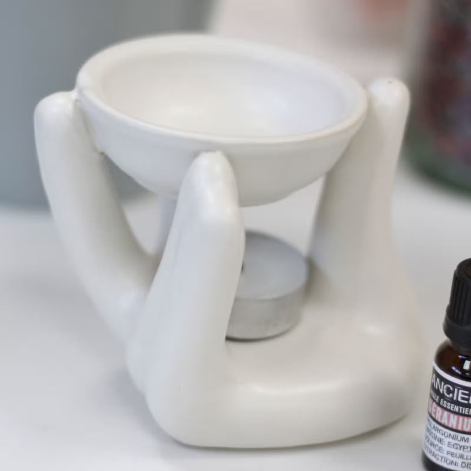 White ceramic diffuser with a bottle of essential oils on a surface