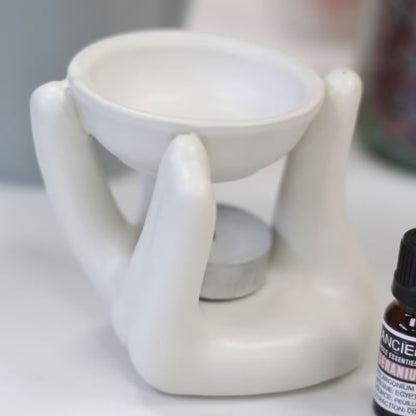 White ceramic diffuser with a bottle of essential oils on a surface