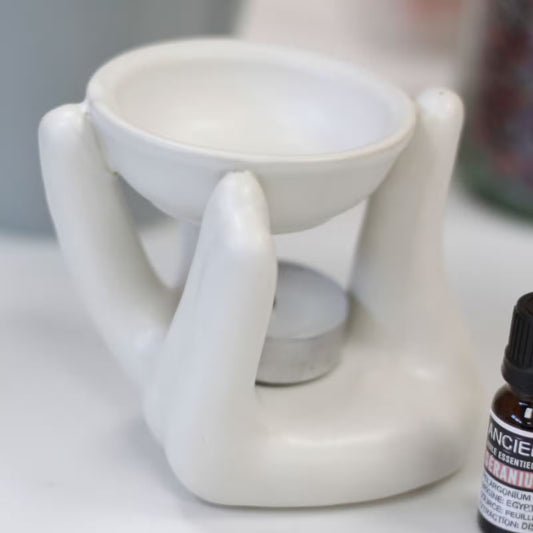 White ceramic diffuser with a bottle of essential oils on a surface